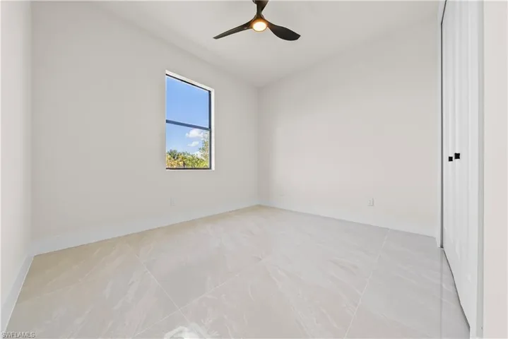 Spare room with lofted ceiling and ceiling fan