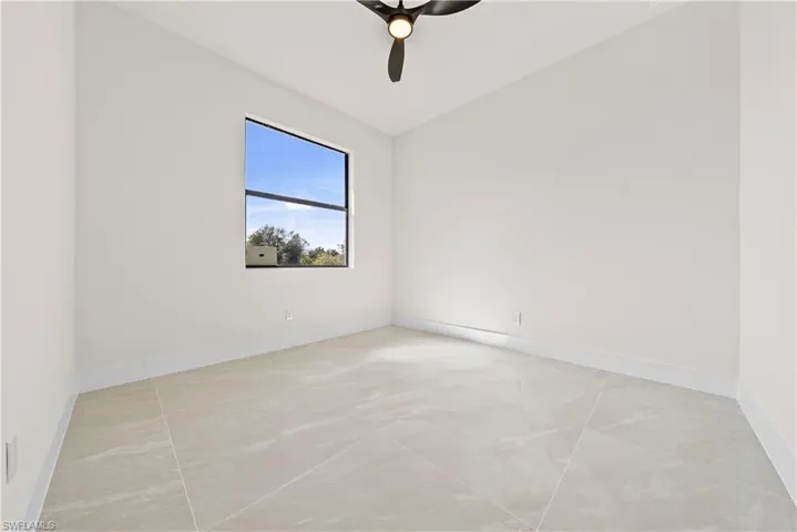 Spare room featuring lofted ceiling and a ceiling fan