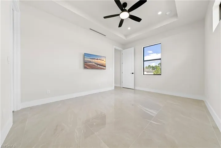 Unfurnished room with a ceiling fan, a tray ceiling, and recessed lighting
