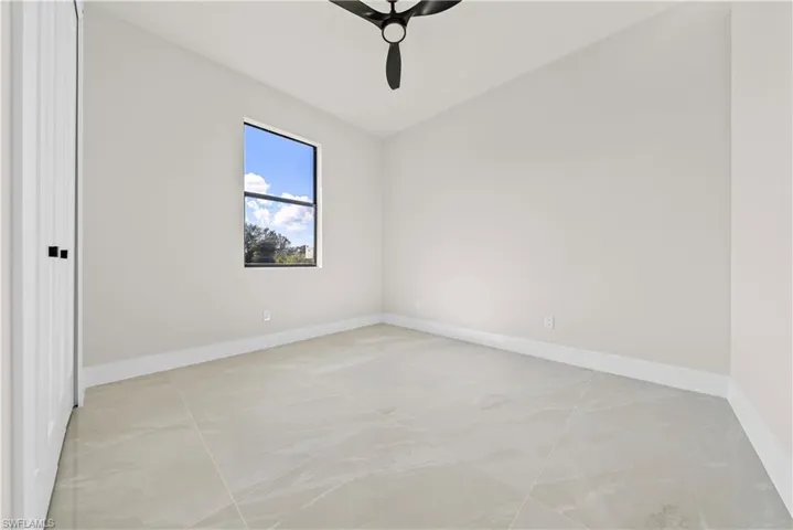 Empty room with lofted ceiling and ceiling fan