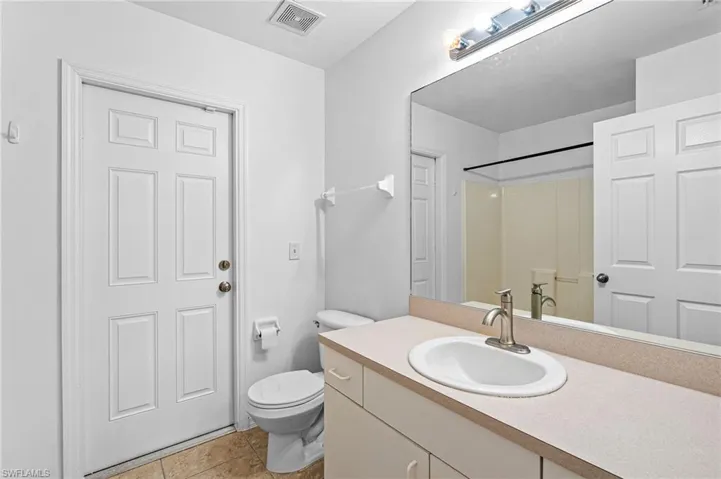 Full bathroom with vanity, light tile patterned flooring, and a shower