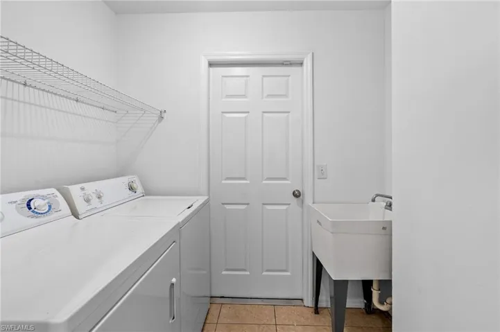 Laundry area with light tile patterned floors and independent washer and dryer