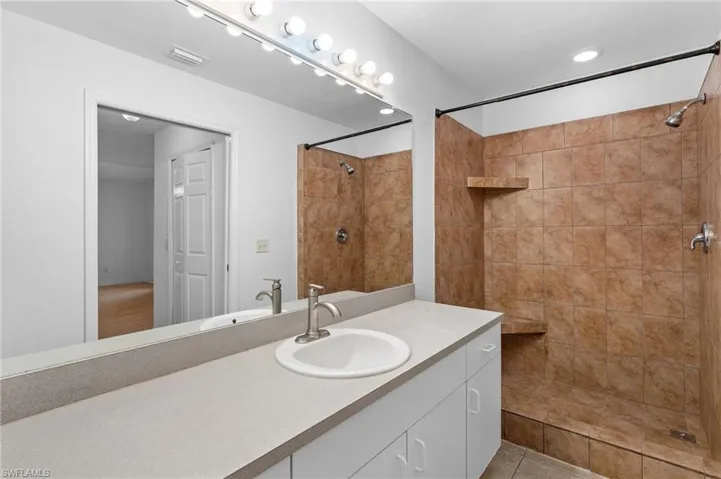 Bathroom featuring vanity and tiled shower