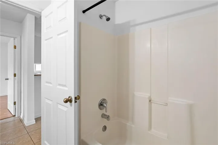 Full bathroom with tub / shower combination and light tile patterned flooring