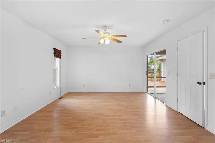 Unfurnished room featuring light wood finished floors, ceiling fan, and plenty of natural light