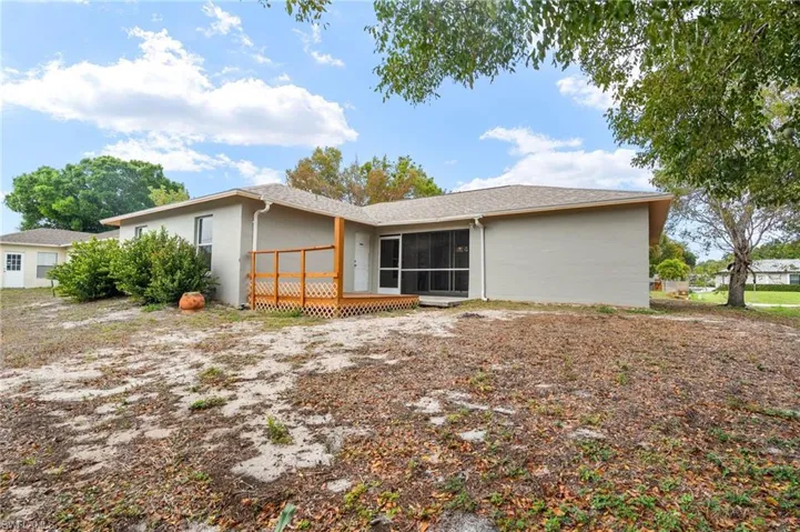 Rear view of property with stucco siding and a wooden deck