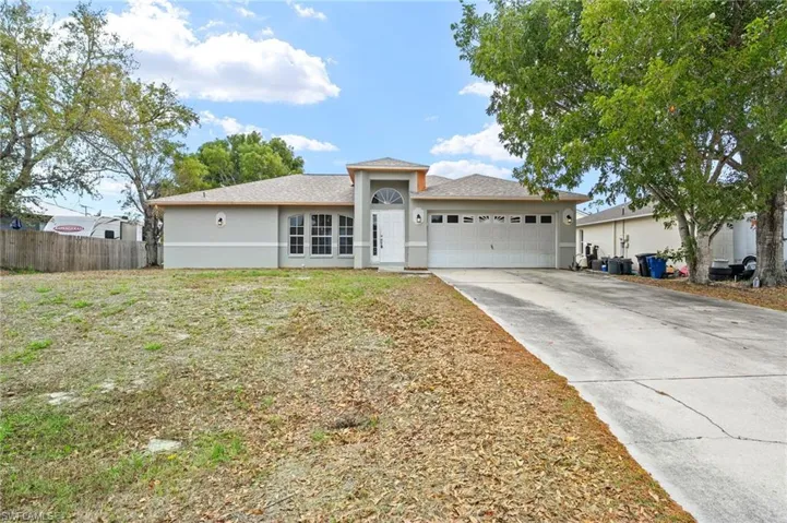 Single story home featuring an attached garage, driveway, and stucco siding