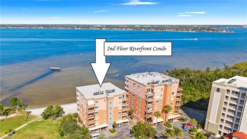 Drone / aerial view of a nearby body of water and apartment complex / building