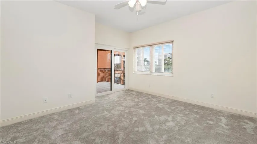 Carpeted empty room with baseboards and ceiling fan