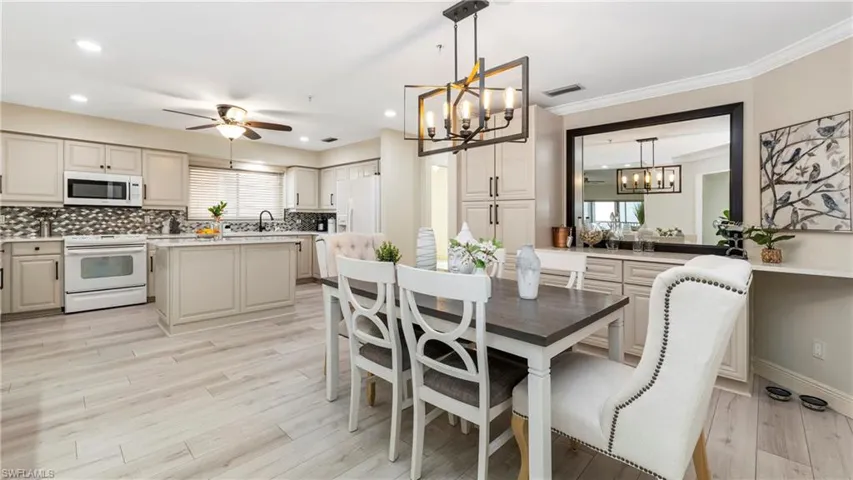 Dining room with a chandelier, light wood-style floors, plenty of natural light, a ceiling fan, and recessed lighting