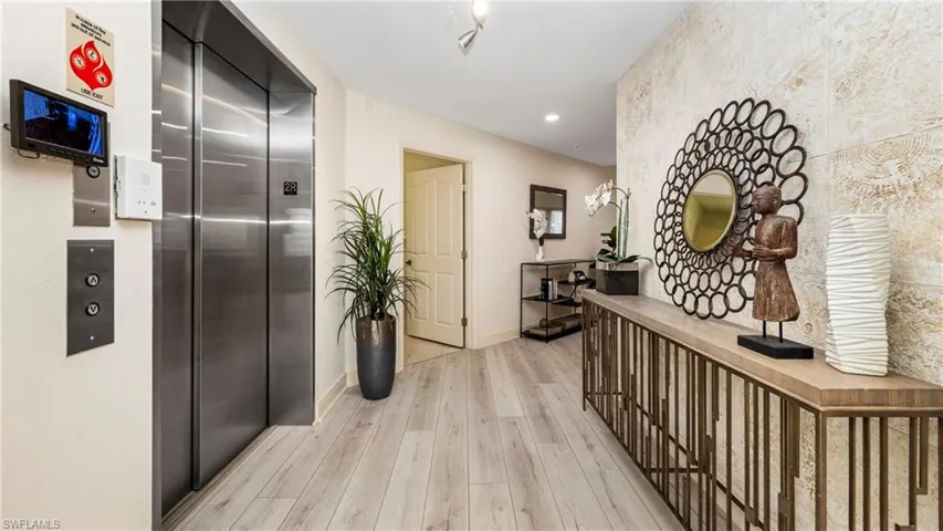 Hall featuring elevator, light wood-style flooring, and recessed lighting