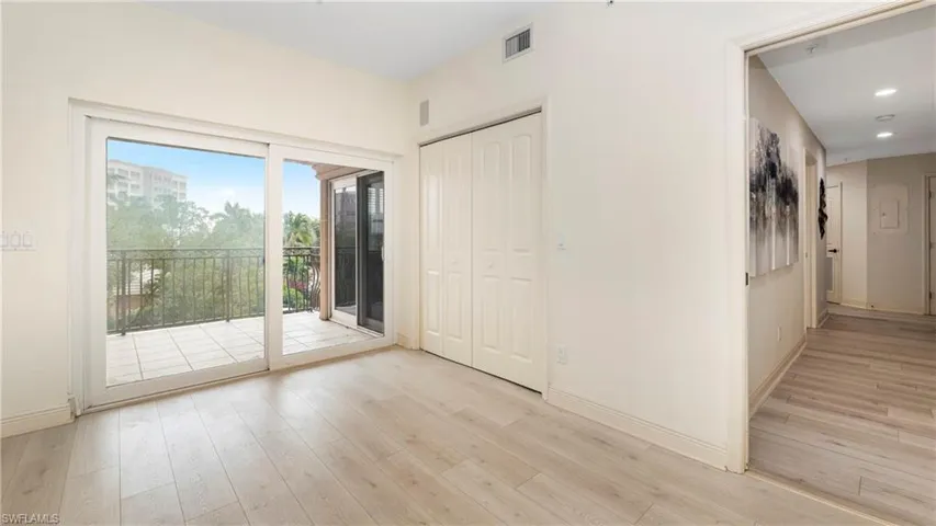 Unfurnished bedroom featuring access to exterior, light wood finished floors, and a closet