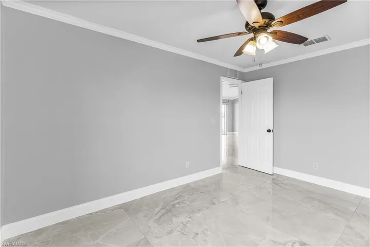 Unfurnished room with ceiling fan and crown molding