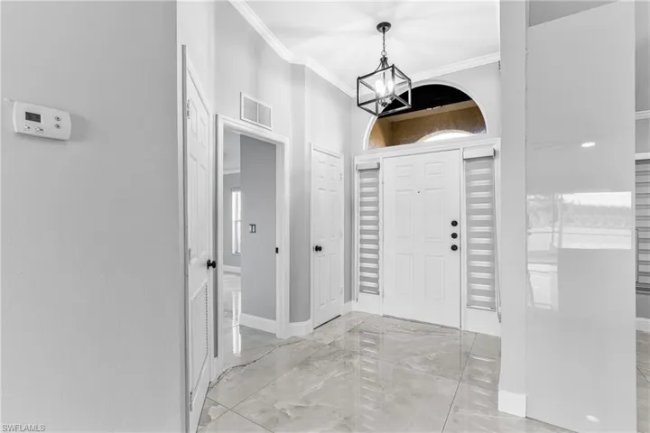 Entryway featuring a chandelier and ornamental molding