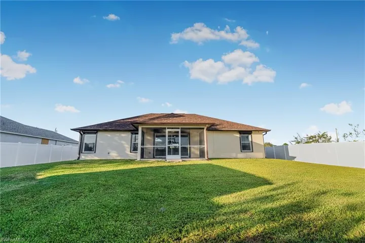 Back of house featuring a sunroom and a lawn