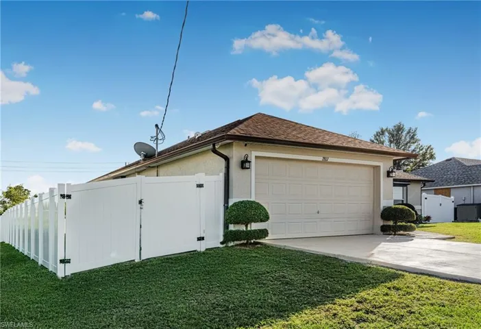 View of side of property with a garage and a yard