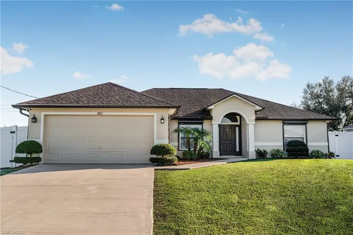 Single story home with a garage and a front yard