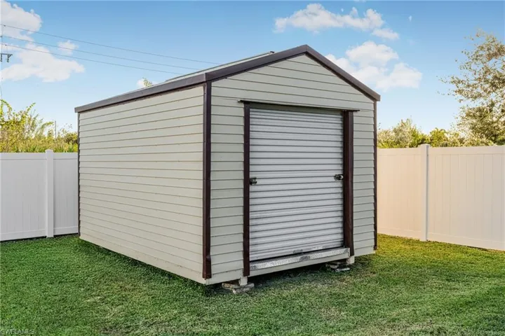 View of outbuilding with a lawn