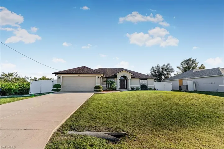 View of front of house with a garage and a front lawn