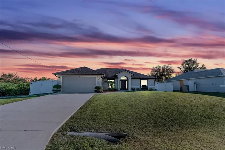 View of front of home featuring a garage and a yard