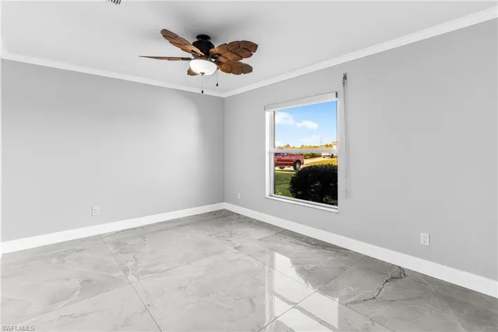 Spare room with ceiling fan and crown molding