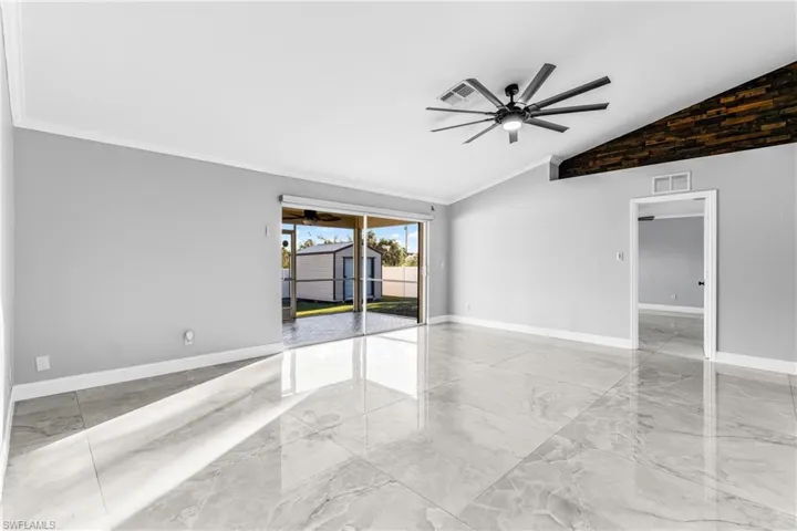 Unfurnished room with ceiling fan, crown molding, and vaulted ceiling