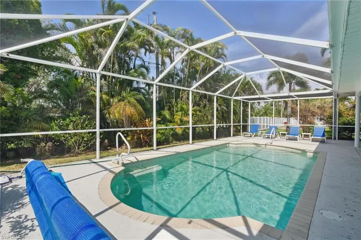 View of pool featuring a patio, glass enclosure, and a fenced in pool