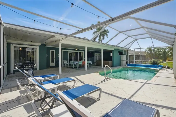 Outdoor pool featuring a patio, a ceiling fan, outdoor dining space, and glass enclosure