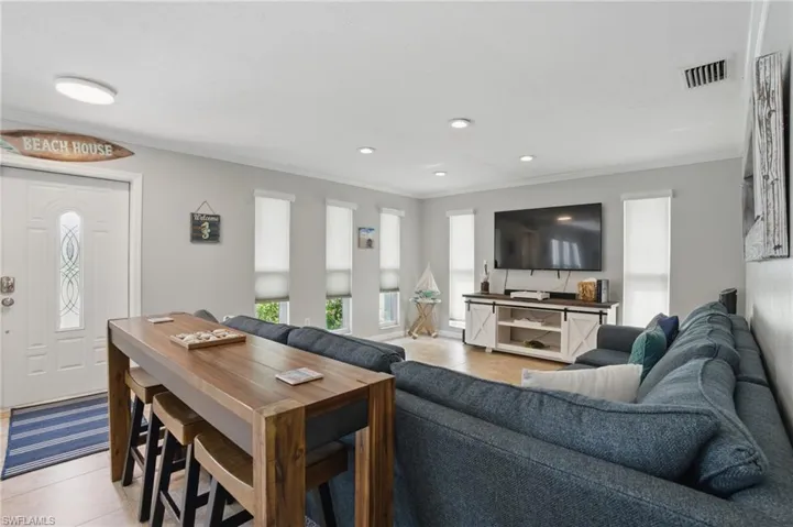 Living area featuring recessed lighting, crown molding, visible vents, and light tile patterned floors