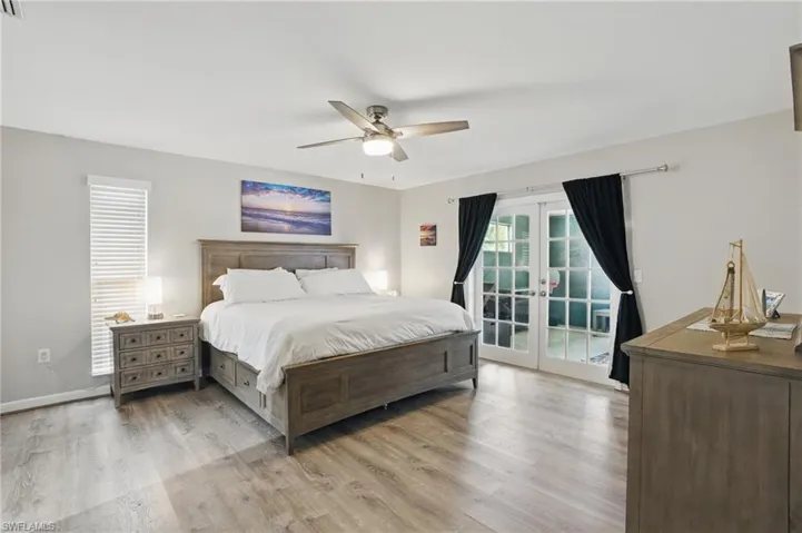 Bedroom with french doors, light wood-type flooring, baseboards, a ceiling fan, and access to outside