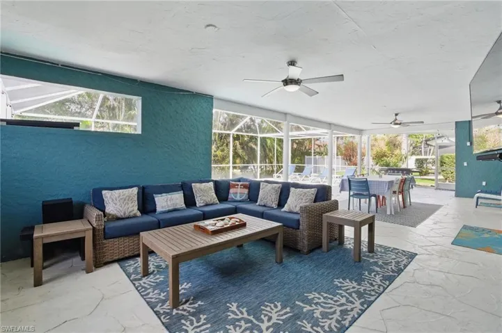 View of patio / terrace featuring an outdoor living space, outdoor dining space, glass enclosure, and ceiling fan