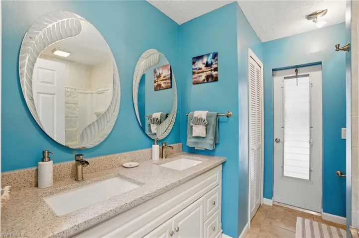 Bathroom with tile patterned flooring, a sink, double vanity, and curtained shower