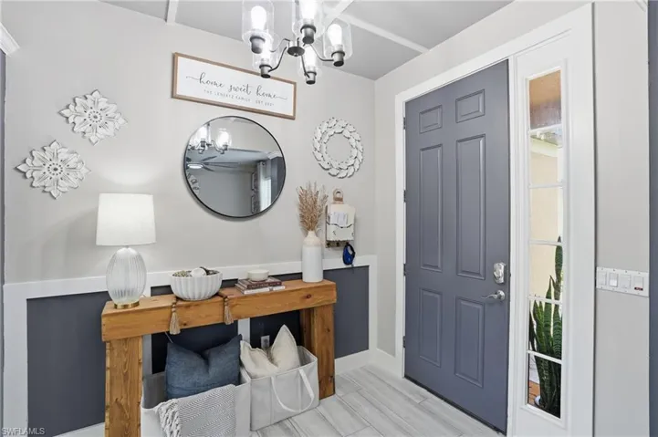 Entryway featuring a paneled door with sidelight, wood-finish flooring, and crown molding accents
