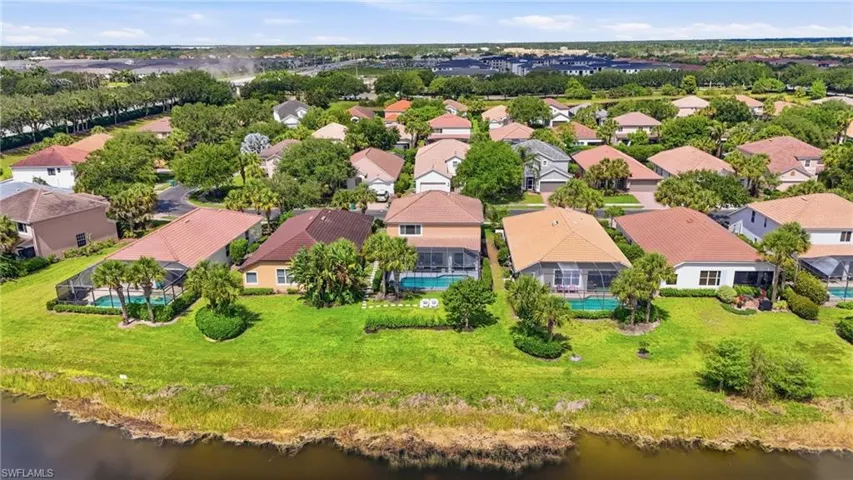 Residential neighborhood featuring single-family homes with tile roofs, screened pools, and mature landscaping