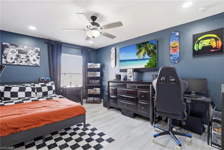 Spacious room featuring light wood-finish flooring, recessed lighting, and a ceiling fan