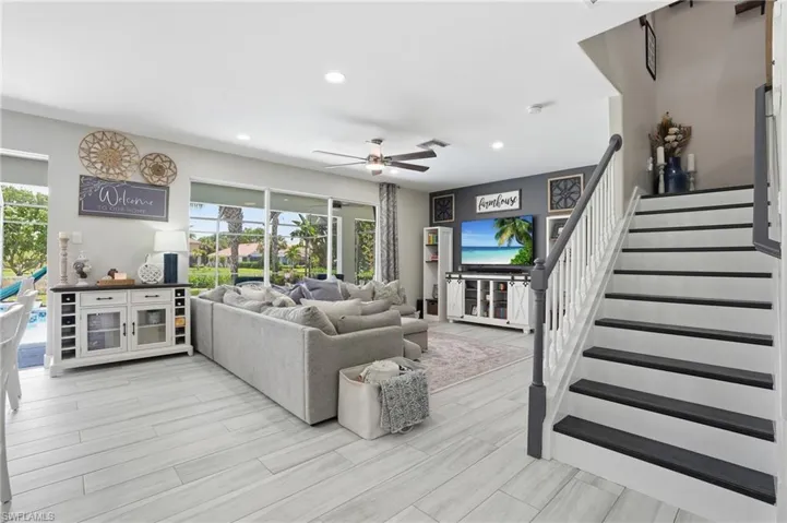 Expansive living area featuring light wood-finish flooring, a ceiling fan, and recessed lighting