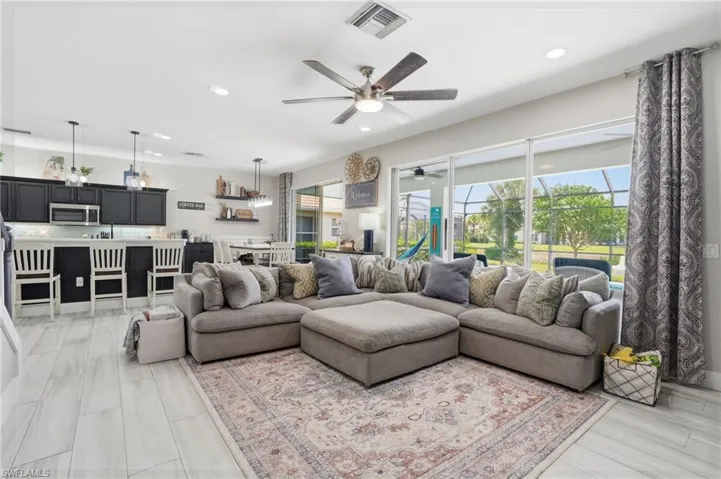 Open concept living area featuring wood-finish tile flooring, recessed lighting, and a ceiling fan
