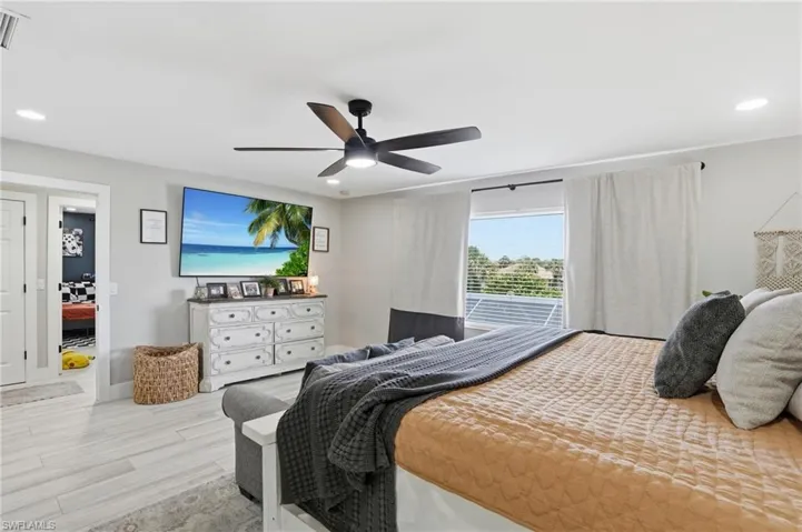 Spacious room with wood-finish flooring, a contemporary ceiling fan with integrated lighting, and recessed ceiling lights