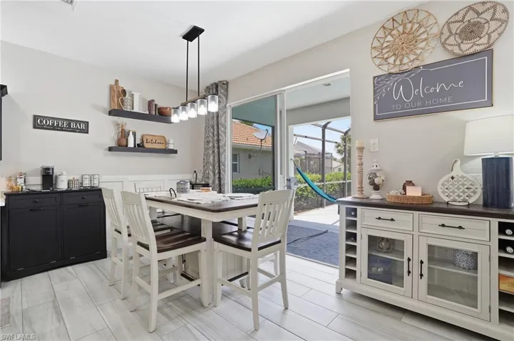 Dining area featuring wood-finish flooring and a contemporary linear light fixture