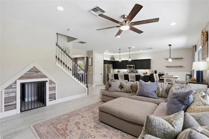 Open-concept living space featuring a custom under-stair enclosure with decorative paneling