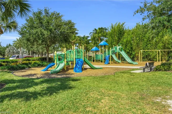 Recreational playground area featuring multiple slides, climbing structures, and a swing set