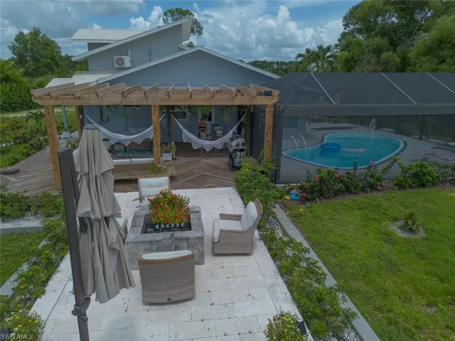 View of patio / terrace with a pergola, an outdoor pool, glass enclosure, and a wooden deck