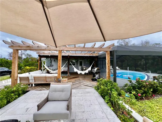 View of patio featuring an outdoor living space, a deck, a pergola, an outdoor pool, and a grill