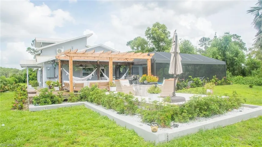 Rear view of property featuring a pergola, a yard, and a patio area