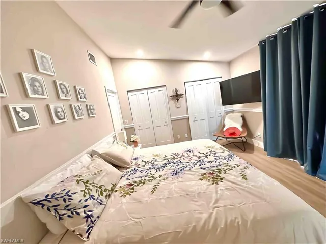 Bedroom with multiple closets, wood finished floors, and ceiling fan