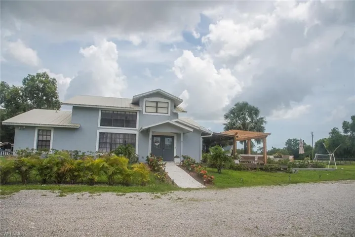 View of front of home featuring a metal roof and stucco siding