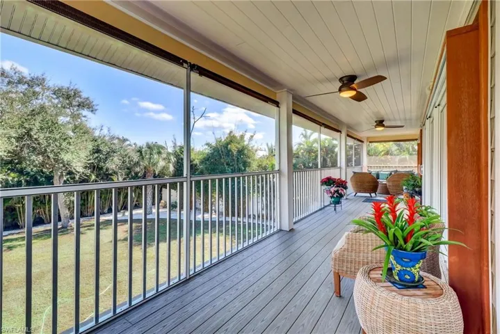 Wooden deck featuring a yard and a ceiling fan