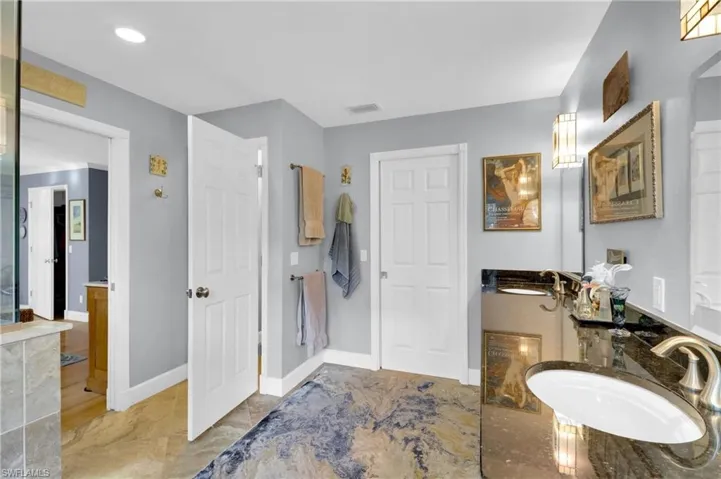 Bathroom with double vanity and baseboards