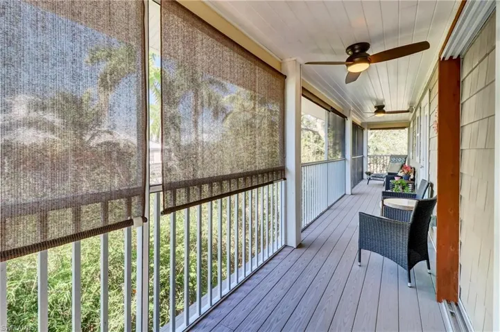 Wooden deck with a ceiling fan and a sunroom