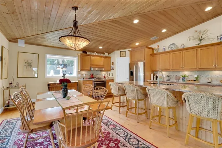 Dining room with lofted ceiling, wooden ceiling, recessed lighting, and light wood-style floors